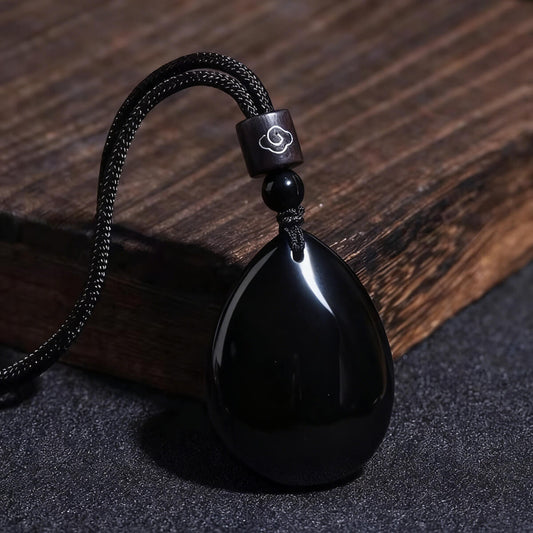 Close-up of polished obsidian pendant showing texture and reflective surface