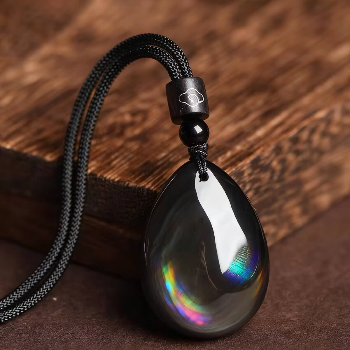 Close-up of polished obsidian pendant showing texture and reflective surface
