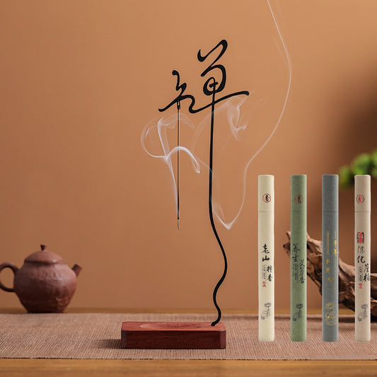 The Inverted Zen Incense Holder made of solid wood and cast iron, presented in a serene desktop setting with the complete set of four complimentary incenses: Sandalwood, Mugwort, Agarwood, and Cypress.