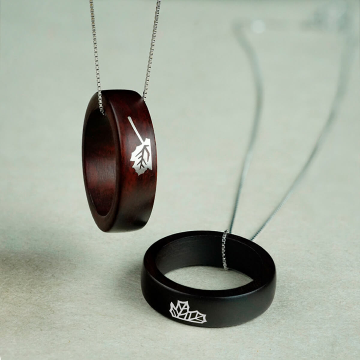 The interlocking maple leaf rings from the Unity Collection, worn as a unified pendant on a chain, symbolizing how two souls remain connected even when apart.