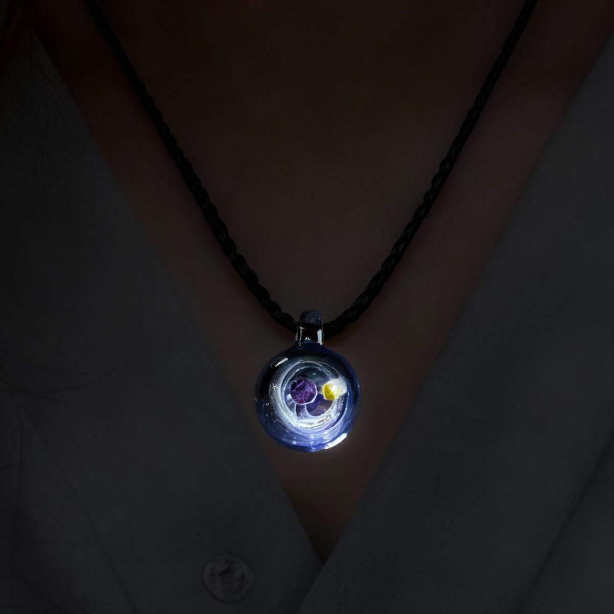 The Cosmic Sphere Pendant worn on a person's neck, showing the elegant scale of the 25mm galaxy sphere as it rests against the skin.